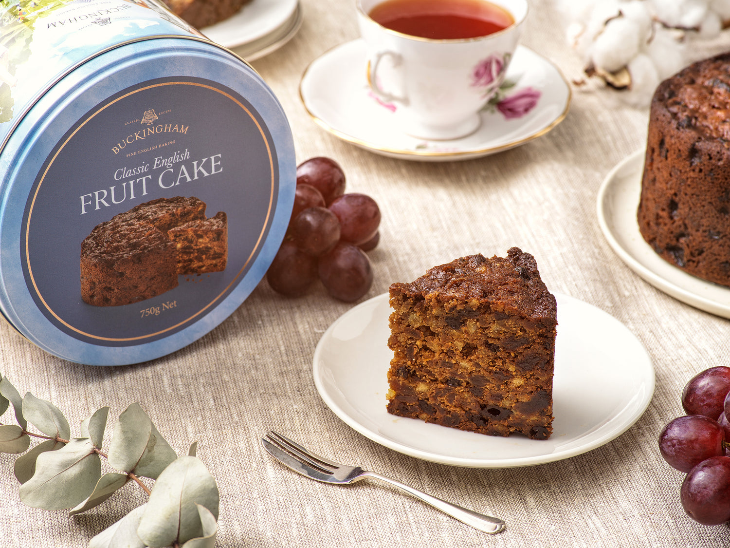 English fruit cake in beautiful gift tin with slice of cake on a plate